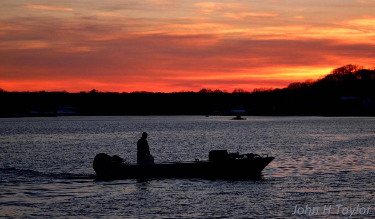 Fisherman in the bay at sunset