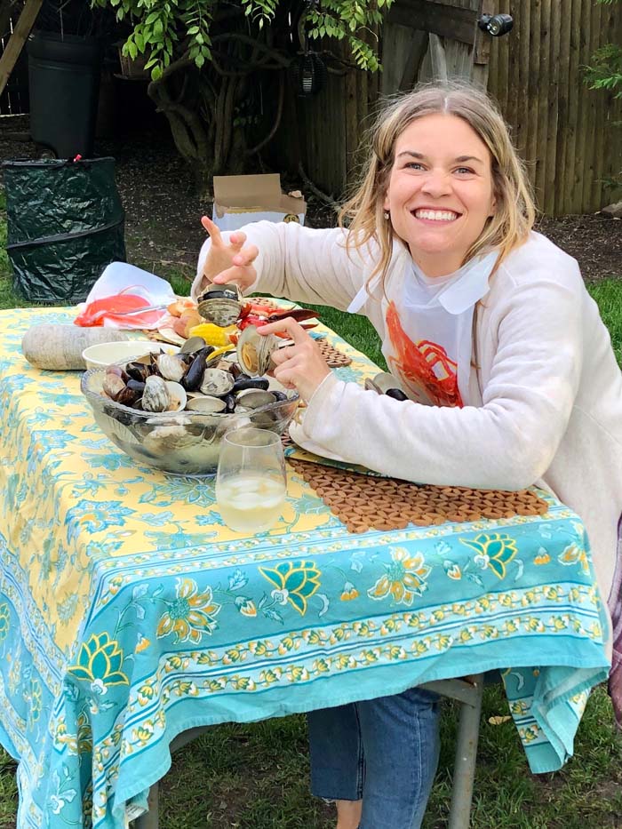 woman looking happy eating at clambake